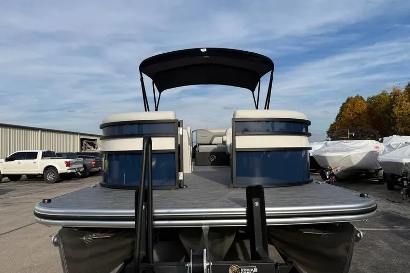 Slide: The Image of 2026 Lowe SS 230 DV pontoon boat with canopy, parked outdoors. - 2