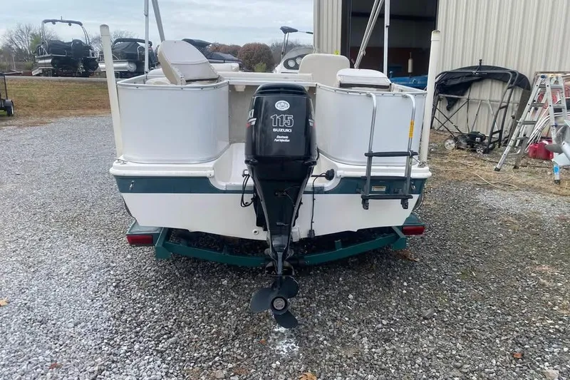 Slide: The Image of 2005 Hurricane FunDeck 196 FF boat with Suzuki 115 outboard motor, parked on gravel. - 2