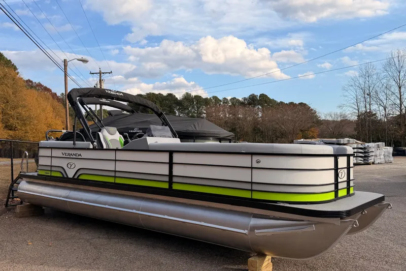 Slide: The Image of 2026 Veranda Vista Sport VS25RC pontoon boat parked outdoors under a blue sky. - 2