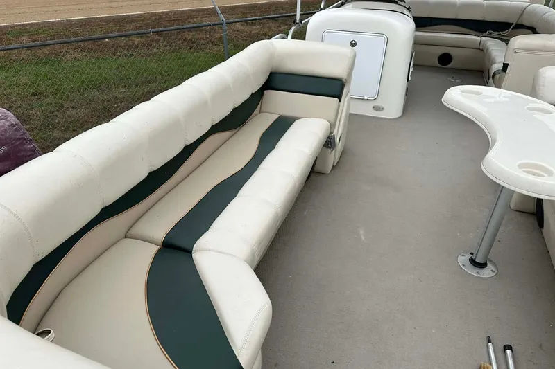 Slide: The Image of 2004 PlayCraft Powertoon 26 interior with white and green seating, and a table. - 12