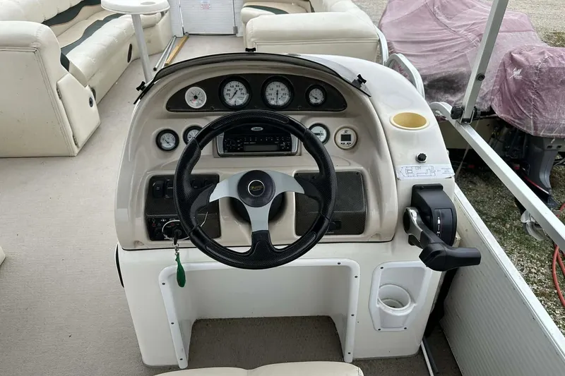Slide: The Image of 2004 PlayCraft Powertoon 26 boat dashboard with steering wheel and control panel. - 3