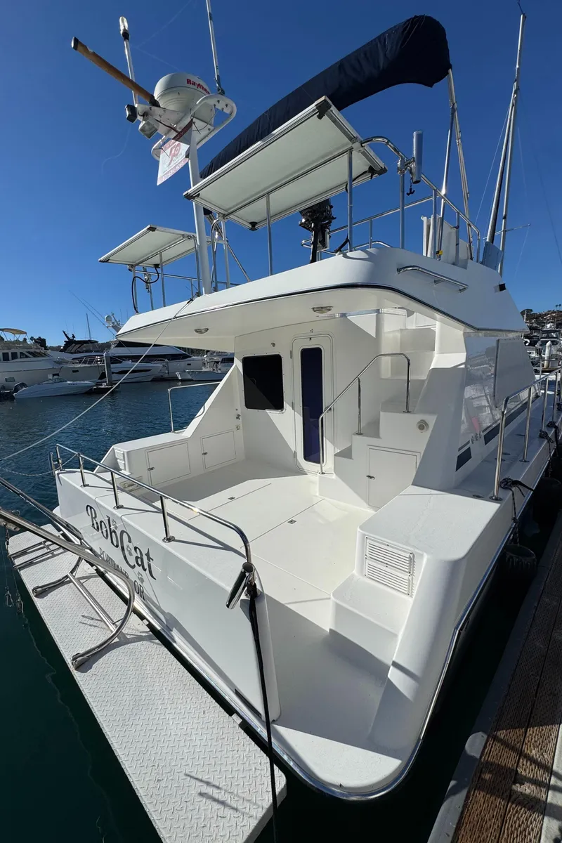 Slide: The Image of 2001 Zeta Flybridge Power Catamaran docked, showcasing spacious deck and sleek design. - 10