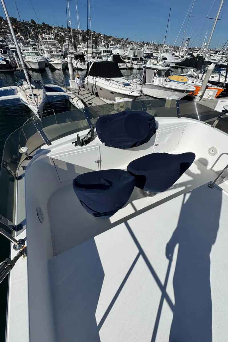 Slide: The Image of 2001 Zeta Flybridge Power Catamaran with blue seats, docked in a marina. - 11