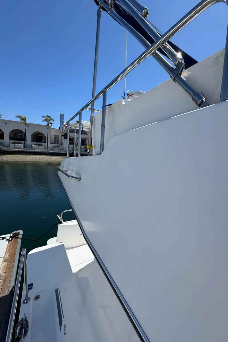 Slide: The Image of 2001 Zeta Flybridge Power Catamaran docked, showcasing sleek design and stainless steel railings. - 13
