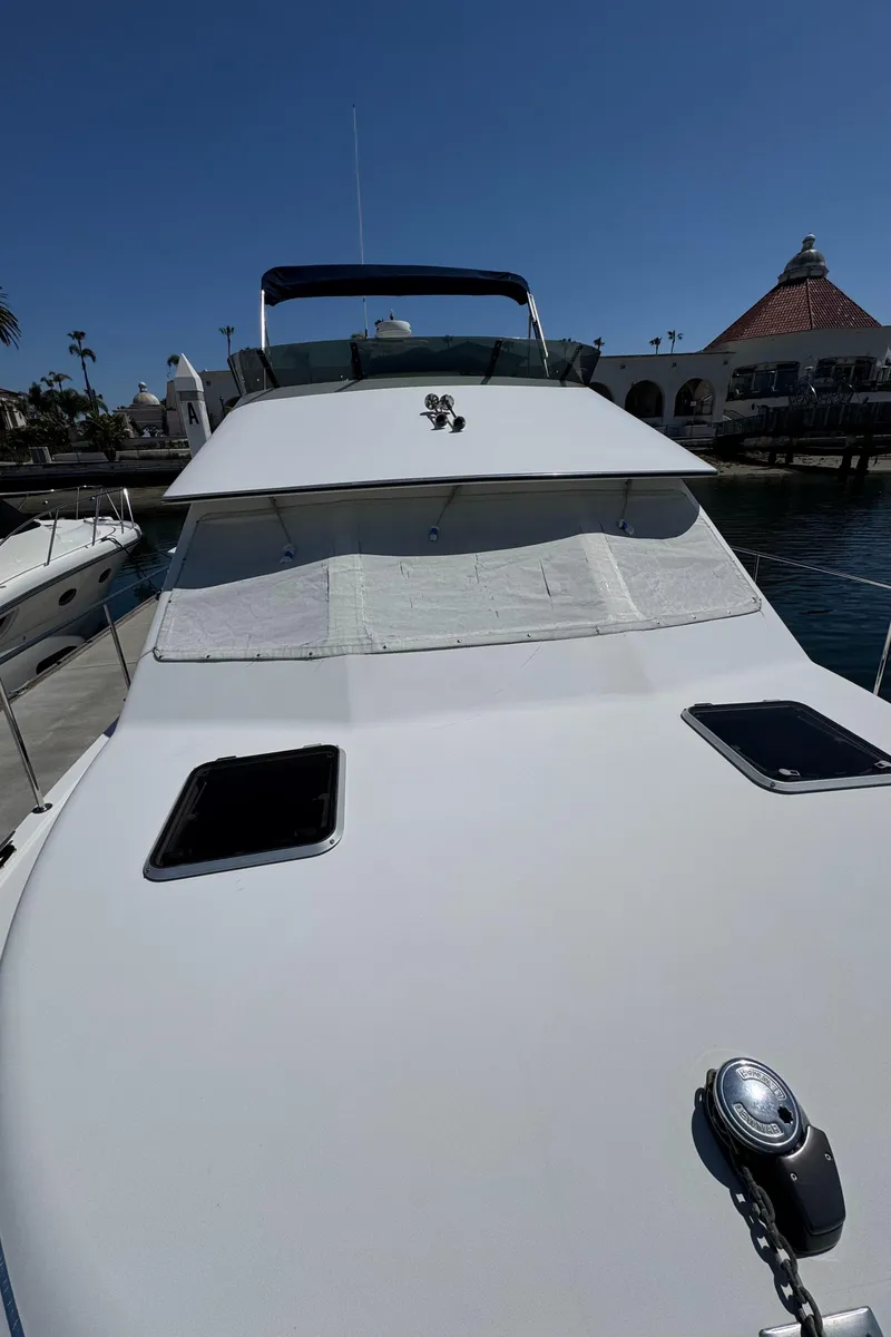 Slide: The Image of 2001 Zeta Flybridge Power Catamaran docked, showcasing sleek design and spacious deck. - 16