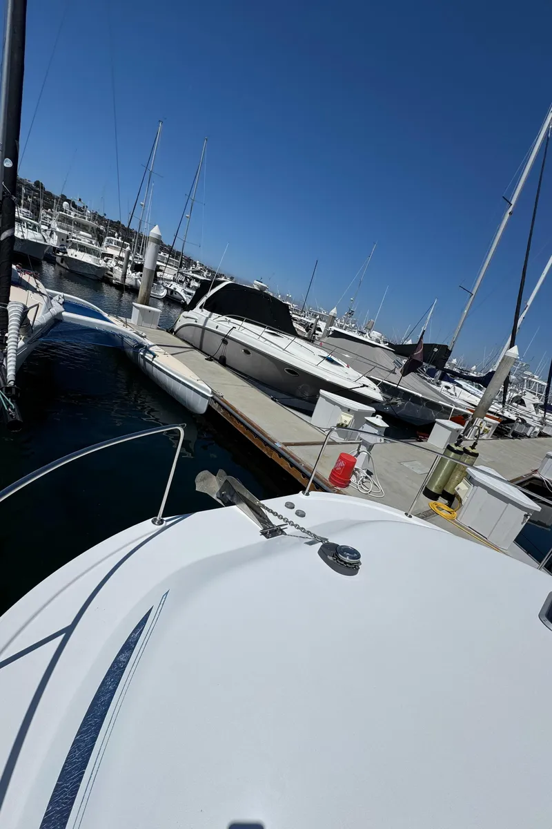 Slide: The Image of 2001 Zeta Flybridge Power Catamaran docked at a marina under clear blue skies. - 19