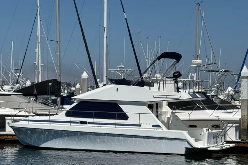 Slide: The Image of 2001 Zeta Flybridge Power Catamaran docked at a marina with other boats. - 2