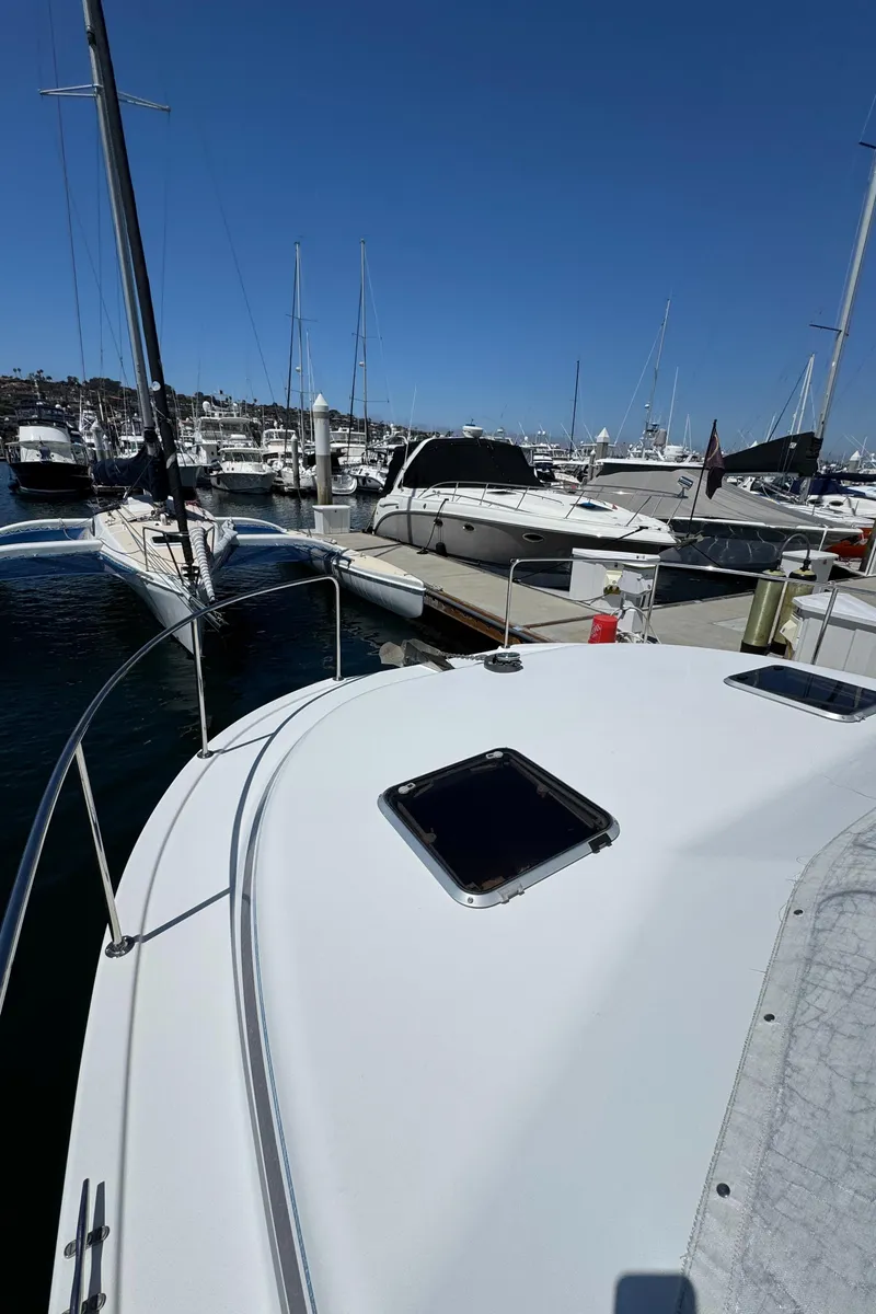 Slide: The Image of 2001 Zeta Flybridge Power Catamaran docked in a marina under clear blue skies. - 20