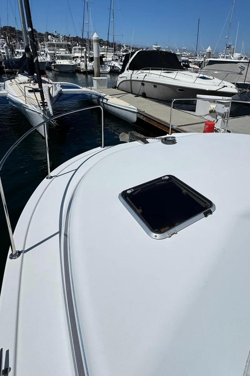 Slide: The Image of 2001 Zeta Flybridge Power Catamaran docked at marina, surrounded by other boats. - 22