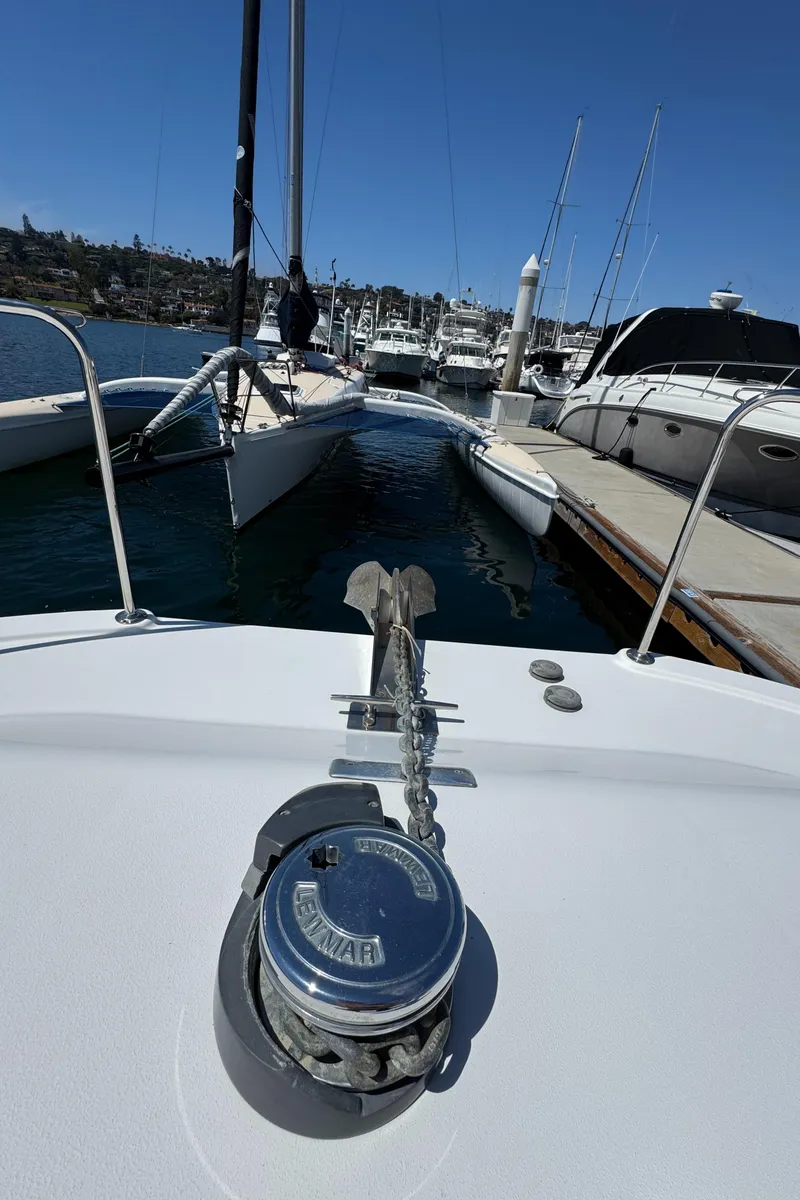 Slide: The Image of 2001 Zeta Flybridge Power Catamaran anchored at marina, showcasing deck and anchor chain. - 25