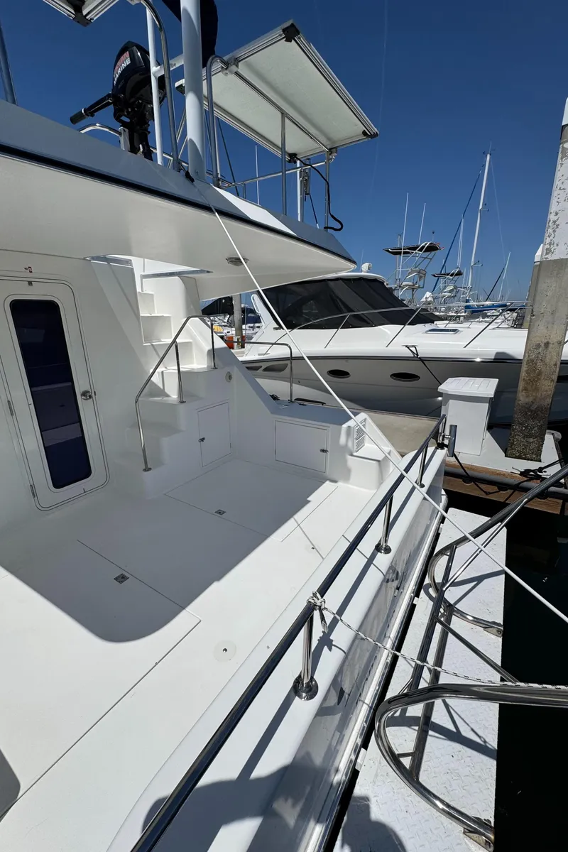Slide: The Image of 2001 Zeta Flybridge Power Catamaran docked at marina under clear blue sky. - 26