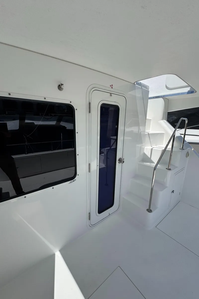 Slide: The Image of 2001 Zeta Flybridge Power Catamaran interior with stairs and door, showcasing sleek design. - 39