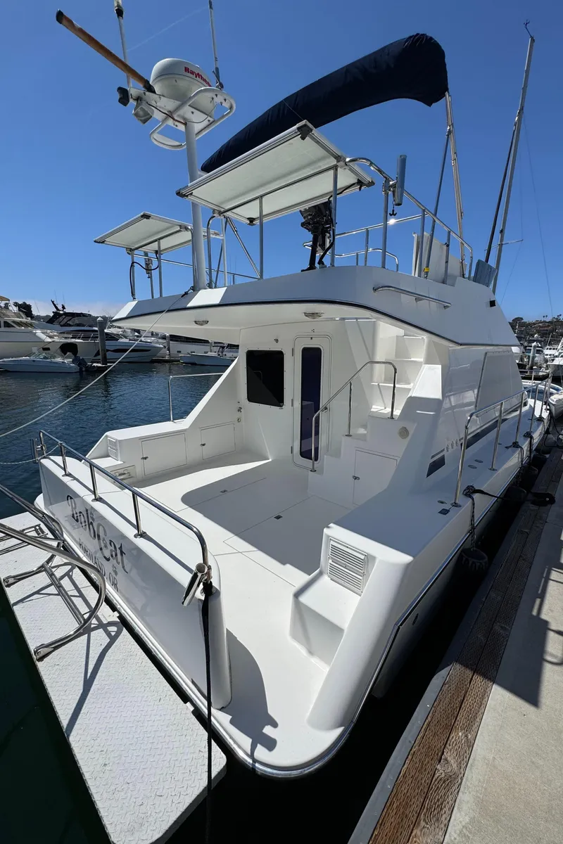 Slide: The Image of 2001 Zeta Flybridge Power Catamaran docked at marina, showcasing spacious deck and sleek design. - 45