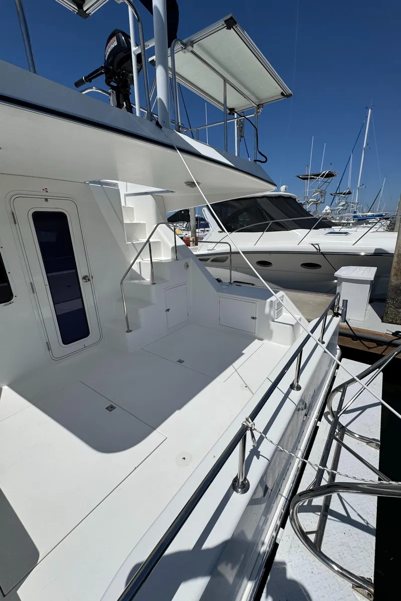 Slide: The Image of 2001 Zeta Flybridge Power Catamaran docked, showcasing sleek design and spacious deck. - 48