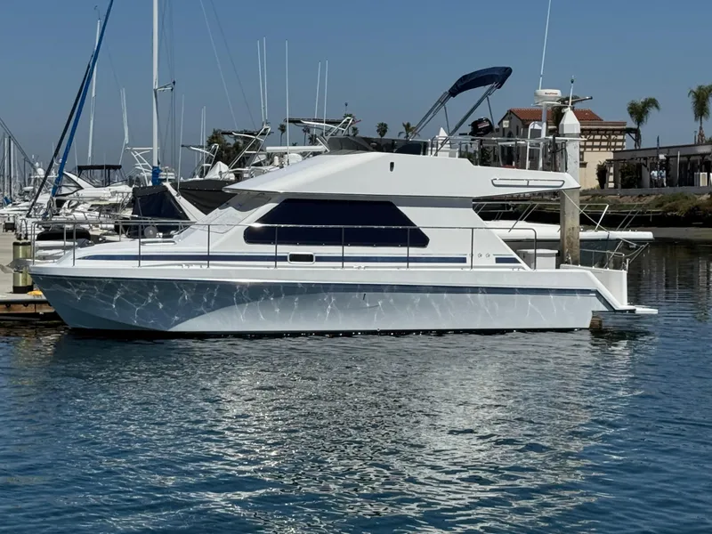 Slide: The Image of 2001 Zeta Flybridge Power Catamaran docked in a marina under clear skies. - 6
