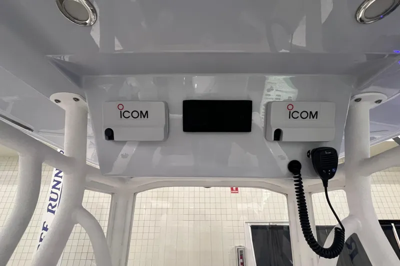 Slide: The Image of 2024 Reef Runner 230 Open boat cruising on ocean with city skyline in background. - 13