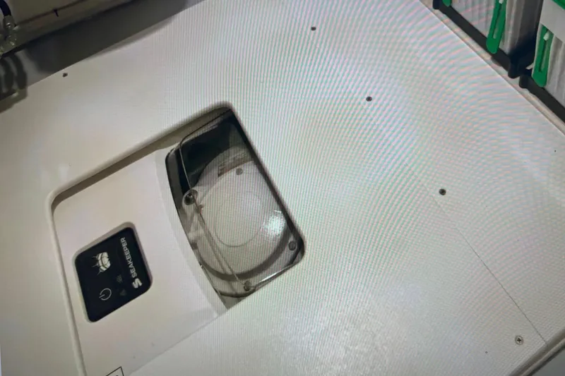 Slide: The Image of 2024 Reef Runner 230 Open boat cruising on blue ocean near city skyline. - 15