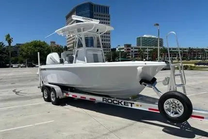 Slide: The Image of 2024 Reef Runner 230 Open boat cruising on ocean with city skyline in background. - 19