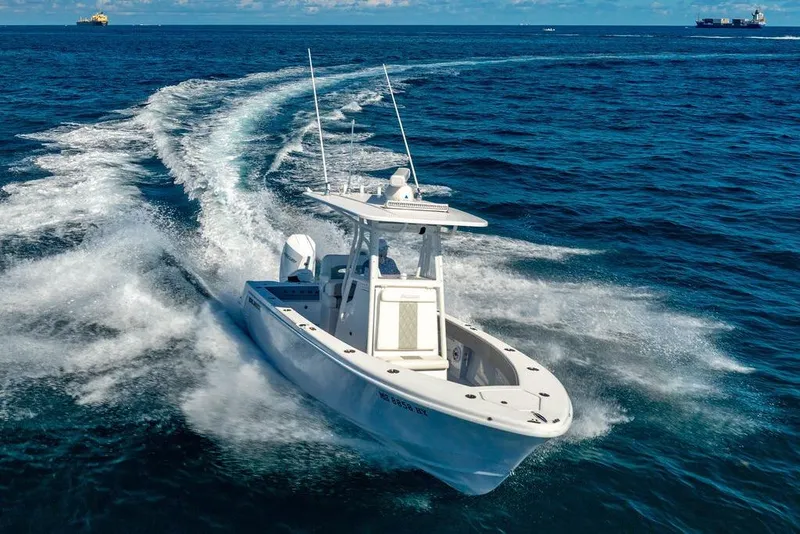 Slide: The Image of 2024 Reef Runner 230 Open boat cruising on open ocean waters. - 24