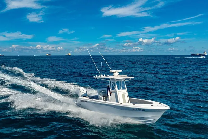 Slide: The Image of 2024 Reef Runner 230 Open boat cruising on open ocean under clear blue sky. - 27