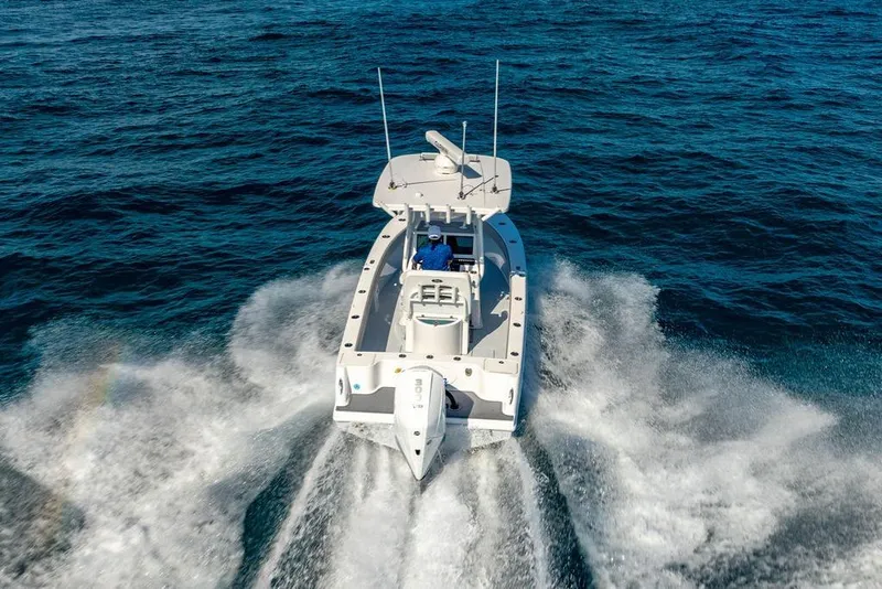 Slide: The Image of 2024 Reef Runner 230 Open boat cruising on open ocean waters. - 38