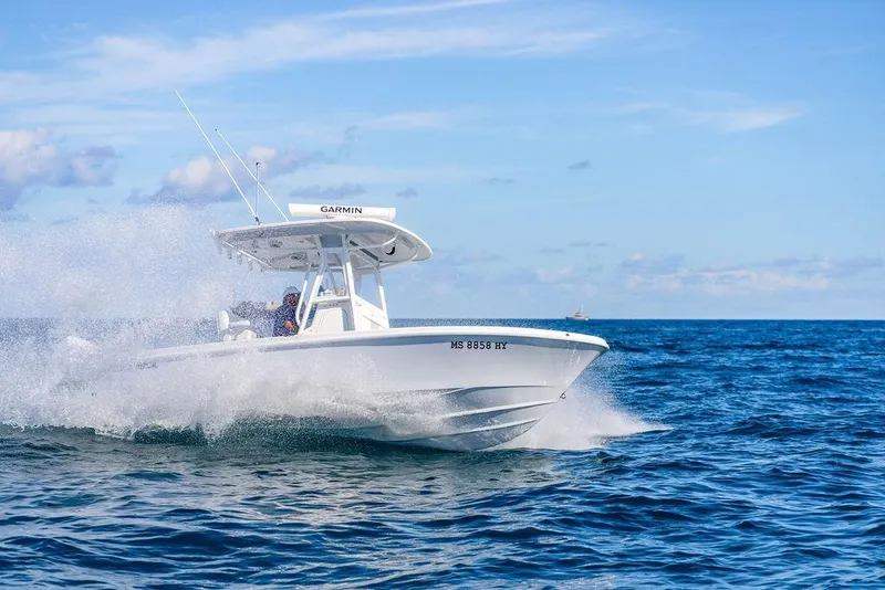 Slide: The Image of 2024 Reef Runner 230 Open boat cruising on ocean waves under clear blue sky. - 40