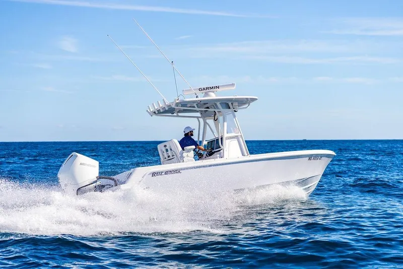 Slide: The Image of 2024 Reef Runner 230 Open boat cruising on the ocean with clear blue skies. - 41