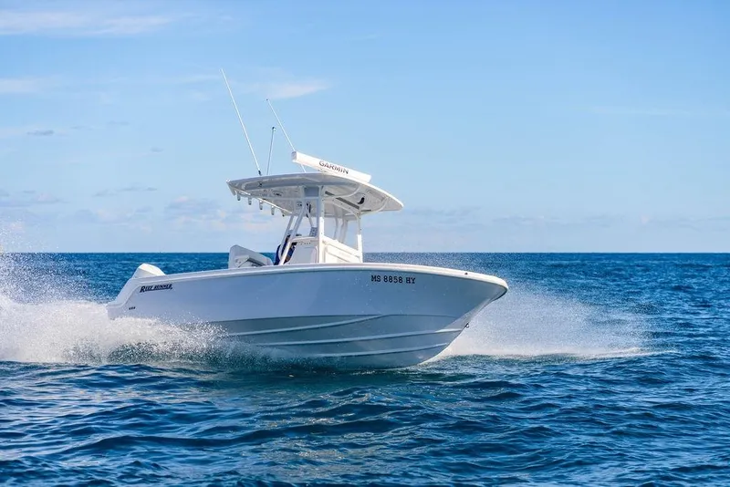 Slide: The Image of 2024 Reef Runner 230 Open boat cruising on open sea under clear blue sky. - 42