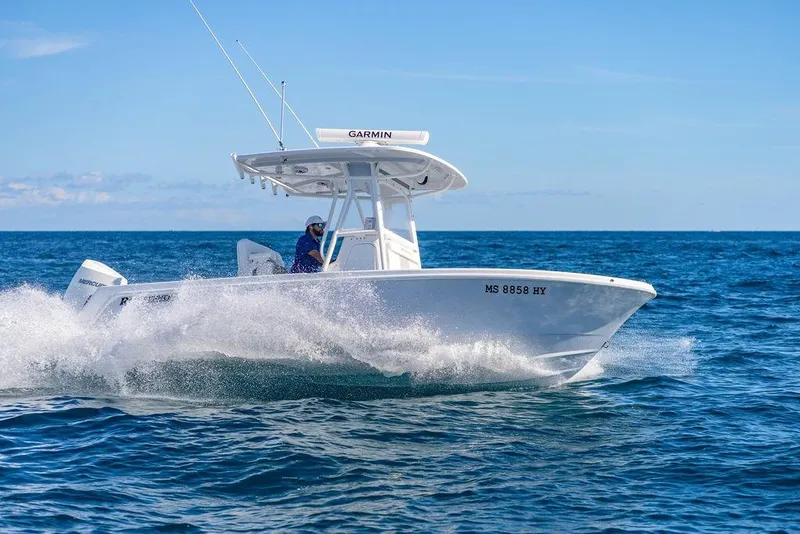 Slide: The Image of 2024 Reef Runner 230 Open boat cruising on open sea under clear blue sky. - 44