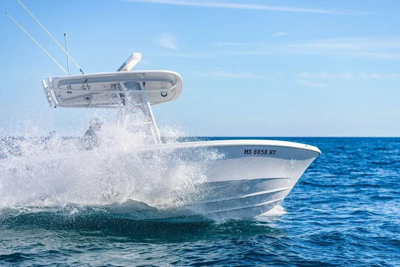 Slide: The Image of 2024 Reef Runner 230 Open boat cruising through ocean waves. - 46