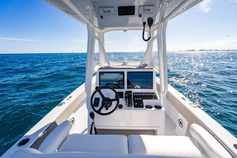 Slide: The Image of 2024 Reef Runner 230 Open boat dashboard with ocean view, featuring modern navigation equipment. - 56