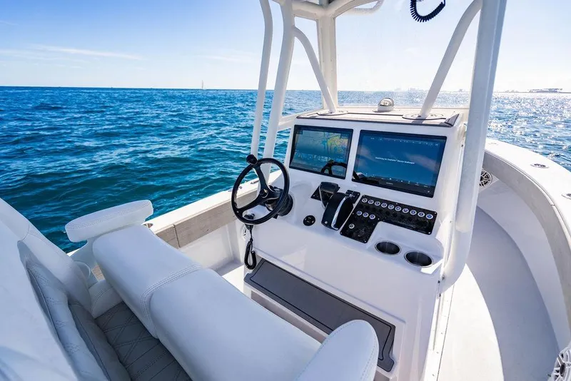 Slide: The Image of 2024 Reef Runner 230 Open boat dashboard with dual screens on open water. - 58