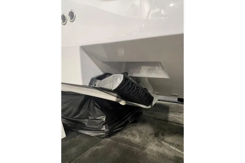 Slide: The Image of 2024 Reef Runner 230 Open boat cruising on water with city skyline background. - 6