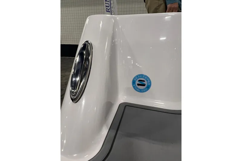 Slide: The Image of 2024 Reef Runner 230 Open boat cruising near city skyline under cloudy sky. - 7