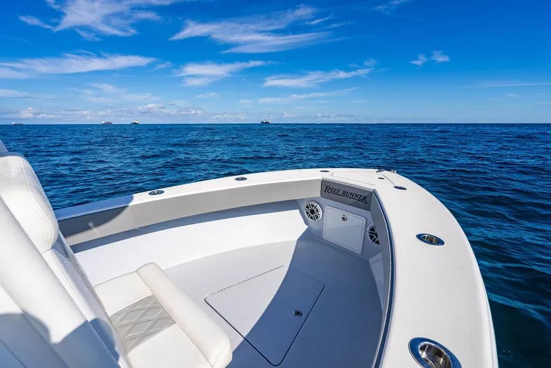 Slide: The Image of 2024 Reef Runner 230 Open boat on open sea under clear blue sky. - 70