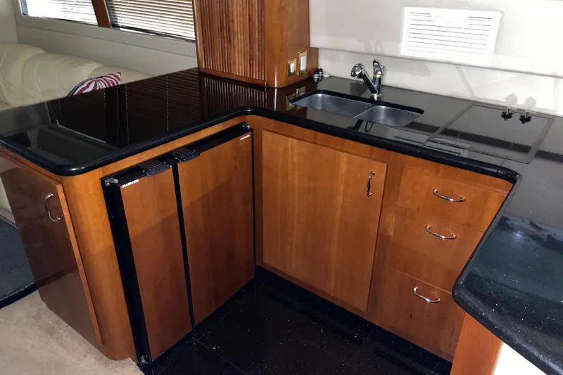Slide: The Image of Luxurious 2004 Carver 460 Voyager yacht kitchen with sleek wood cabinetry and modern appliances. - 18