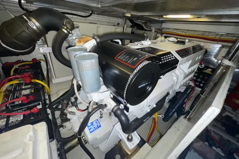 Slide: The Image of Engine room of a 2004 Carver 460 Voyager yacht, showcasing the engine and battery setup. - 25