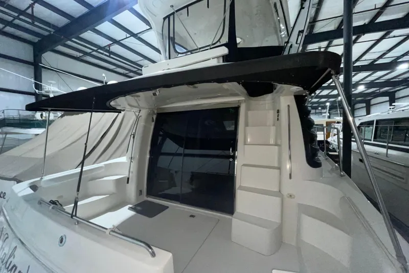 Slide: The Image of 2004 Carver 460 Voyager yacht in indoor storage, rear view with steps and canopy. - 3