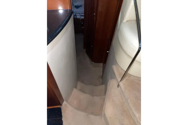 Slide: The Image of Interior stairs of 2004 Carver 460 Voyager yacht with carpeted steps and wooden paneling. - 16
