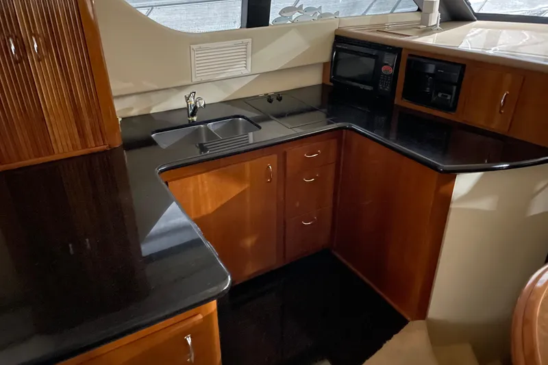 Slide: The Image of 2004 Carver 460 Voyager yacht kitchen with sleek countertops and modern appliances. - 17