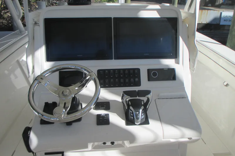 Slide: The Image of Control panel of a 2012 Jupiter 30 FS boat with dual screens and steering wheel. - 10