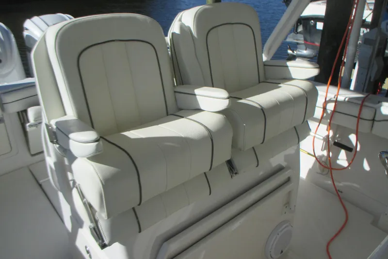 Slide: The Image of Luxury seating on a 2012 Jupiter 30 FS boat, featuring white cushioned chairs. - 13