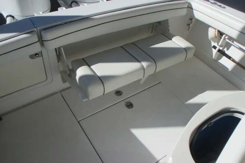 Slide: The Image of 2012 Jupiter 30 FS boat interior with white cushioned seating and storage compartments. - 14