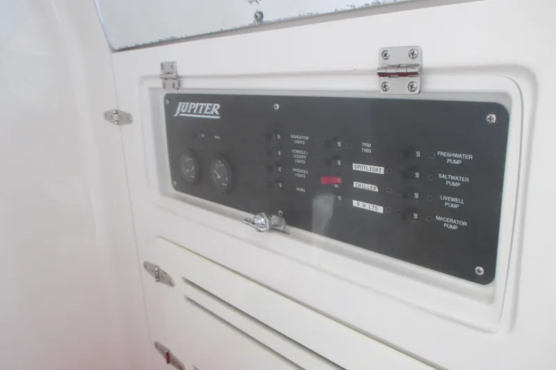 Slide: The Image of Control panel of a 2012 Jupiter 30 FS boat with various switches and gauges. - 17