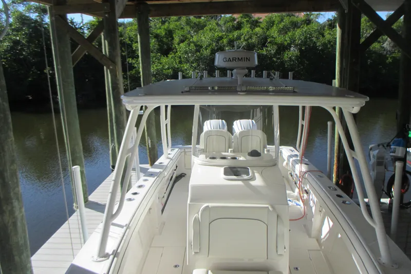Slide: The Image of 2012 Jupiter 30 FS boat docked, featuring Garmin equipment, surrounded by lush greenery. - 18
