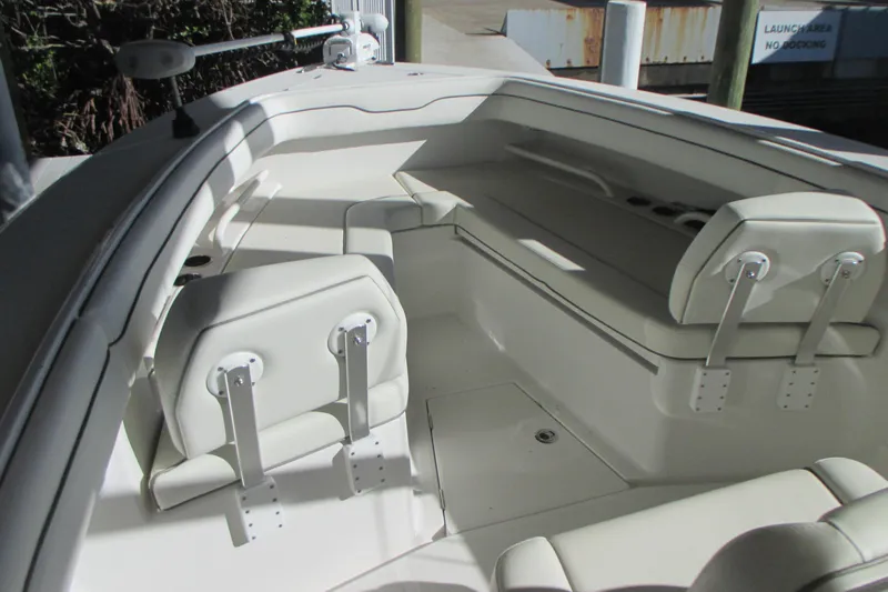 Slide: The Image of Interior of a 2012 Jupiter 30 FS boat with white seating and storage compartments. - 21