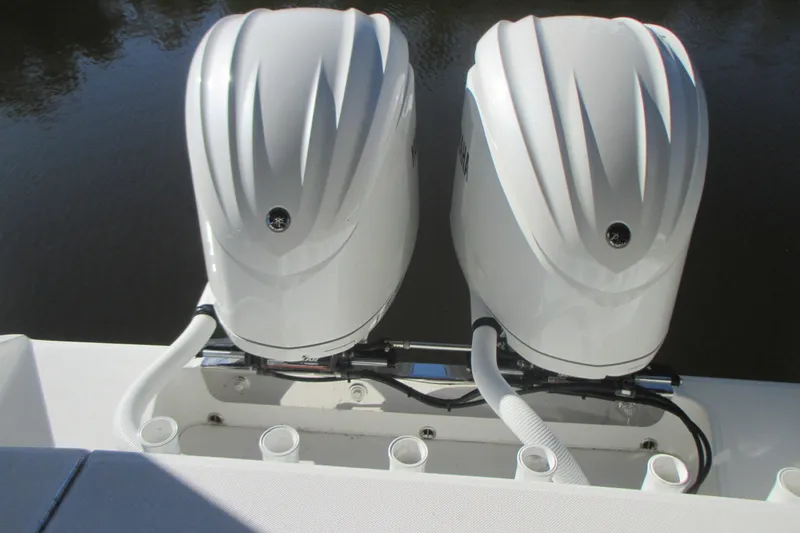 Slide: The Image of Twin outboard engines on a 2012 Jupiter 30 FS boat, docked on calm water. - 5