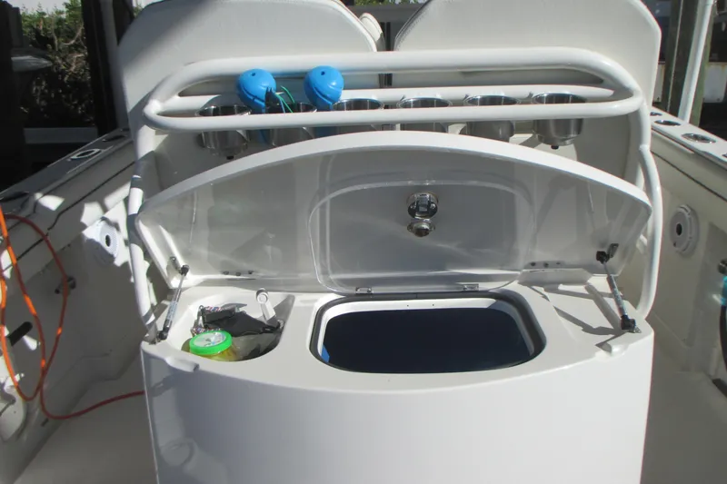 Slide: The Image of Open storage compartment on a 2012 Jupiter 30 FS boat, featuring cup holders and accessories. - 9