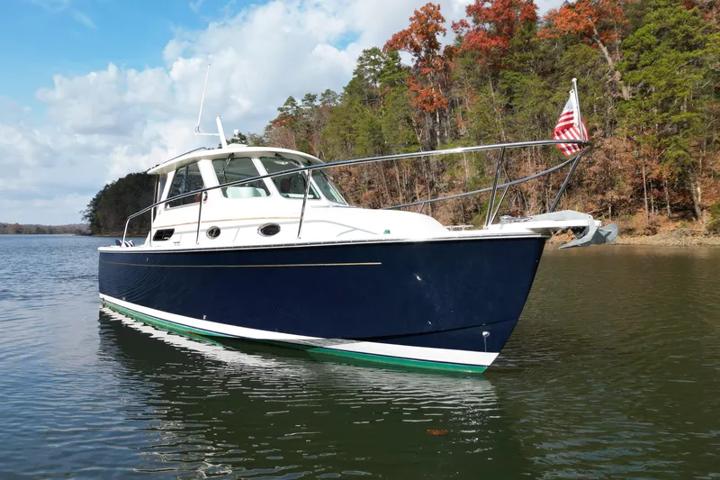 Slide: The Image of 2008 Back Cove 29 boat on a serene lake with autumn trees in the background. - 14