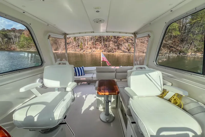 Slide: The Image of Interior of 2008 Back Cove 29 boat with seating, table, and scenic lake view. - 17